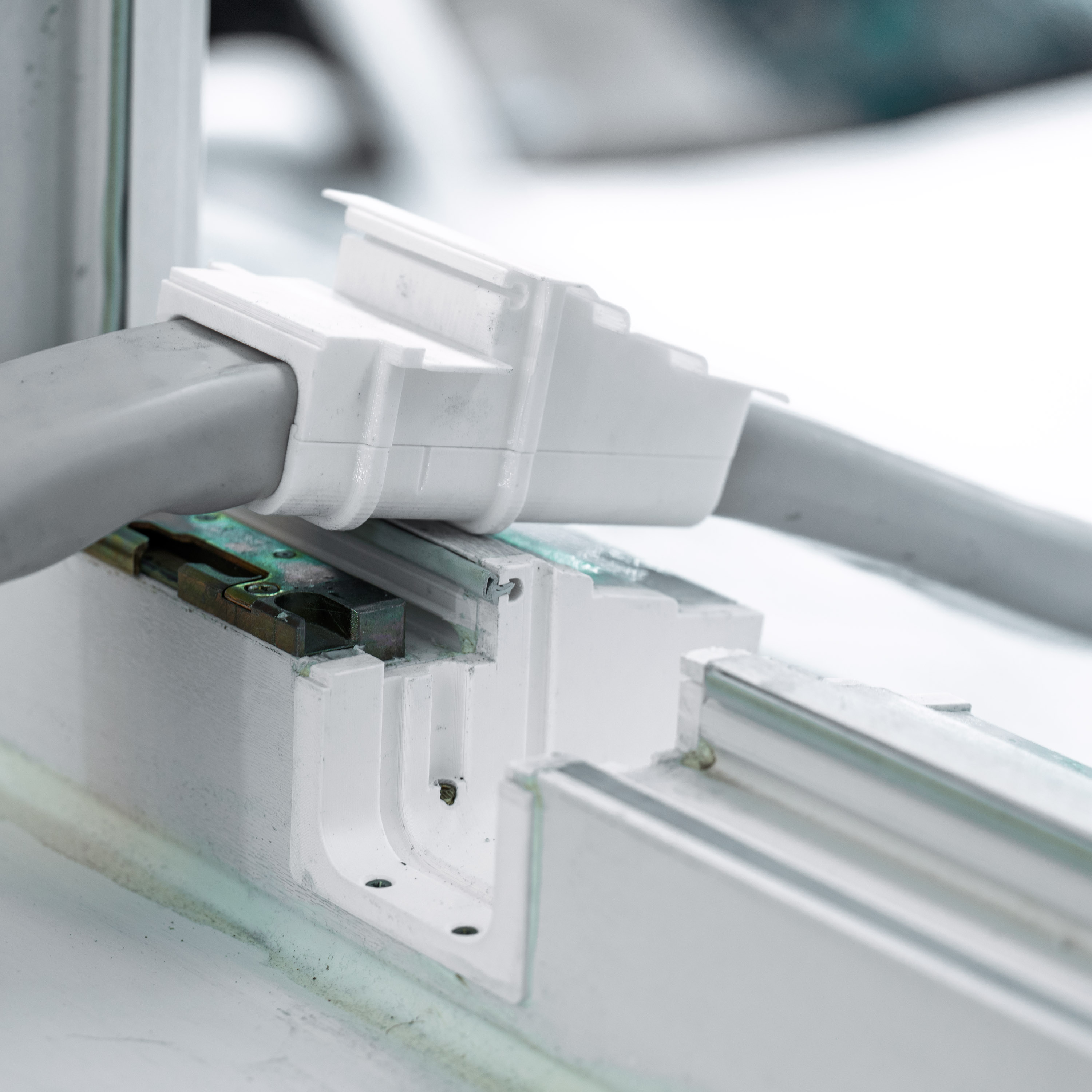 Nahaufnahme des Adapters mit eingesetztem Durchführungseinsatz und durchgeführtem Leitungsbündel.